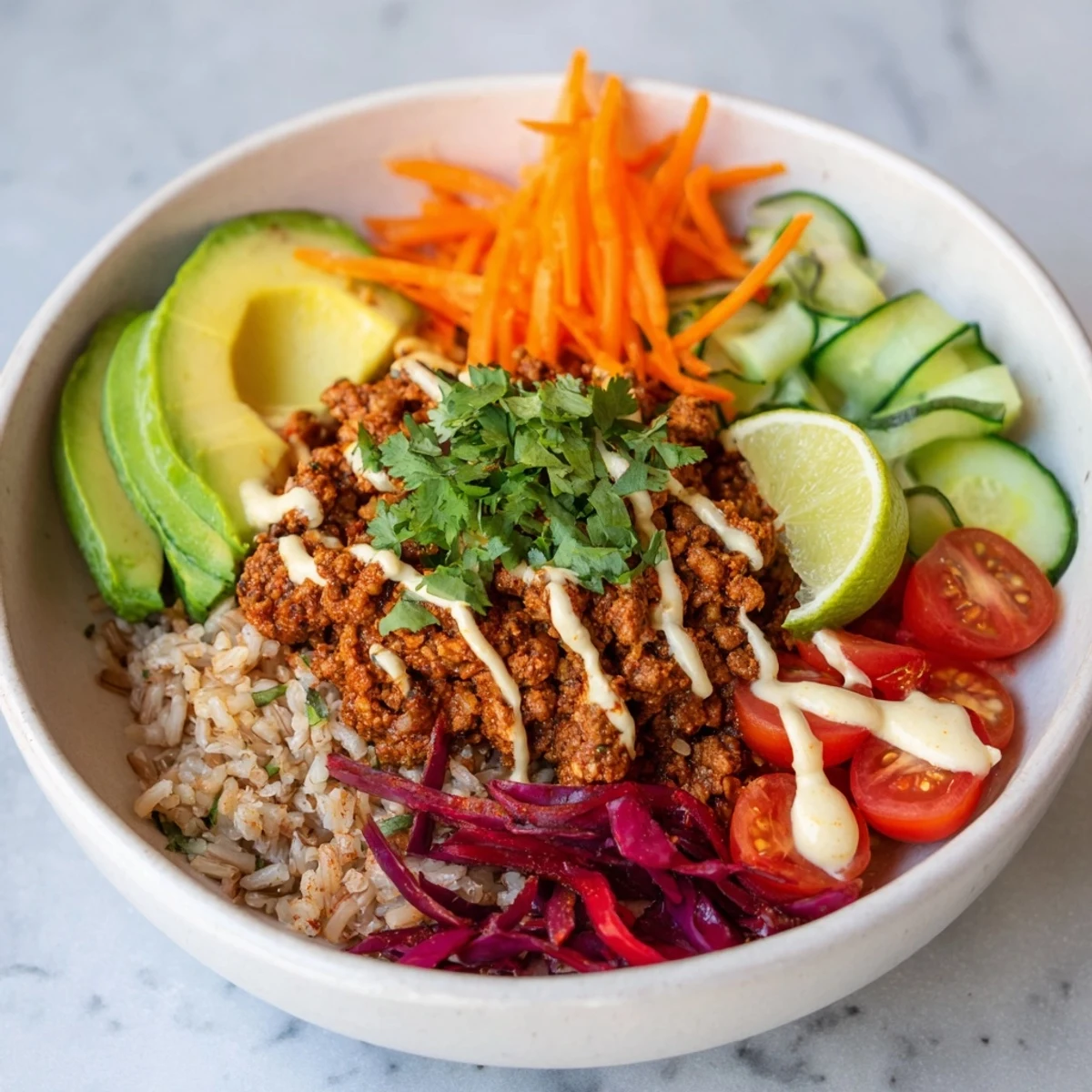 A colorful plant-based meat bowl topped with fresh veggies and spicy mayo.  