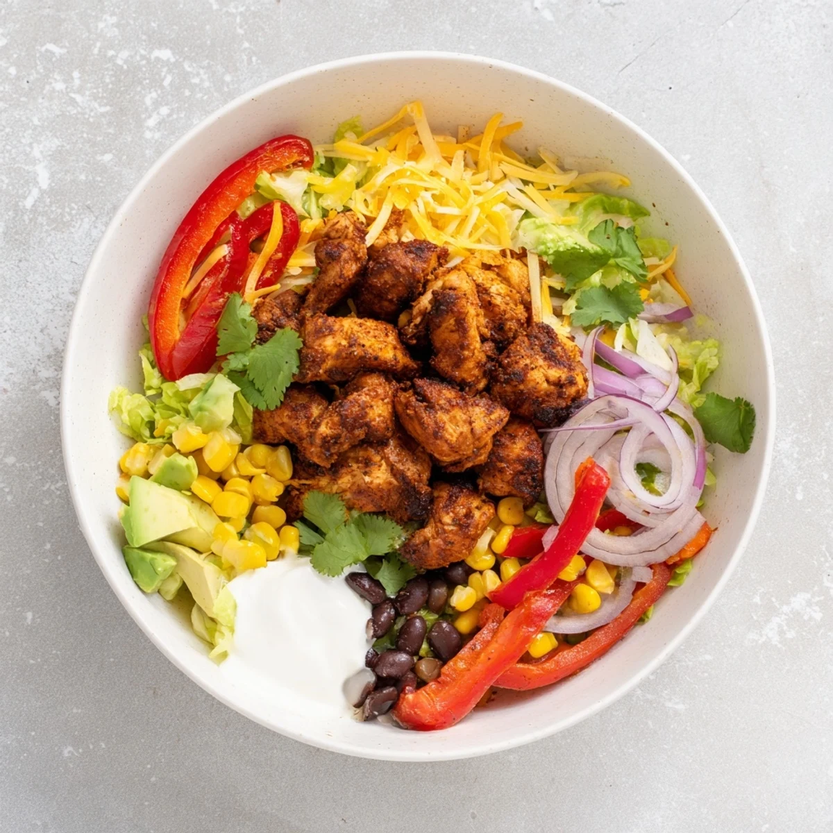 A delicious close-up showcases golden sheet pan chicken burrito bowls, brimming with fresh toppings.
