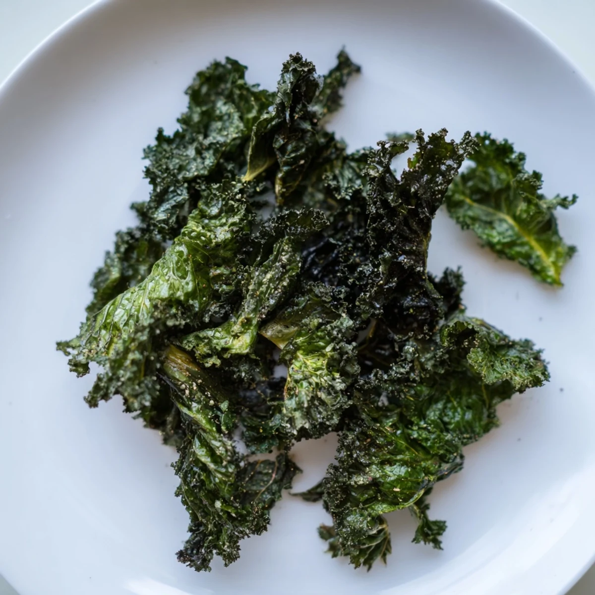 Golden, air-baked kale chips with sea salt, offering a perfectly crispy, healthy snack option.