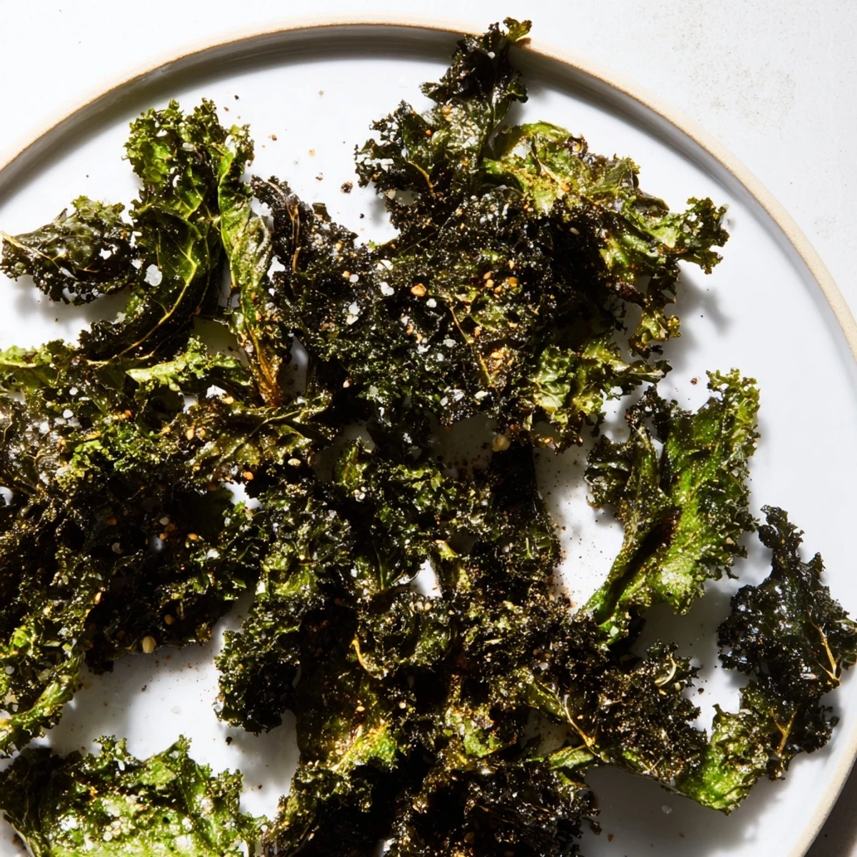 Freshly prepared, crispy baked kale chips, a quick and easy American vegan snack to make.