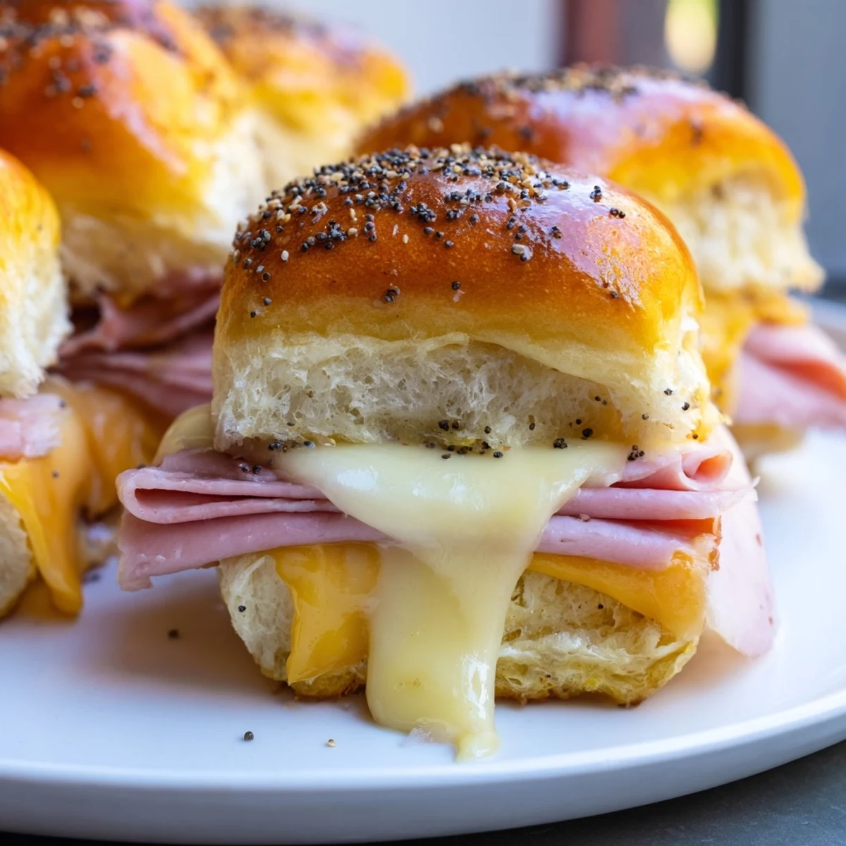Golden-brown Baked Ham and Cheese Party Sliders, melting cheese, savory ham, perfect for a party.
