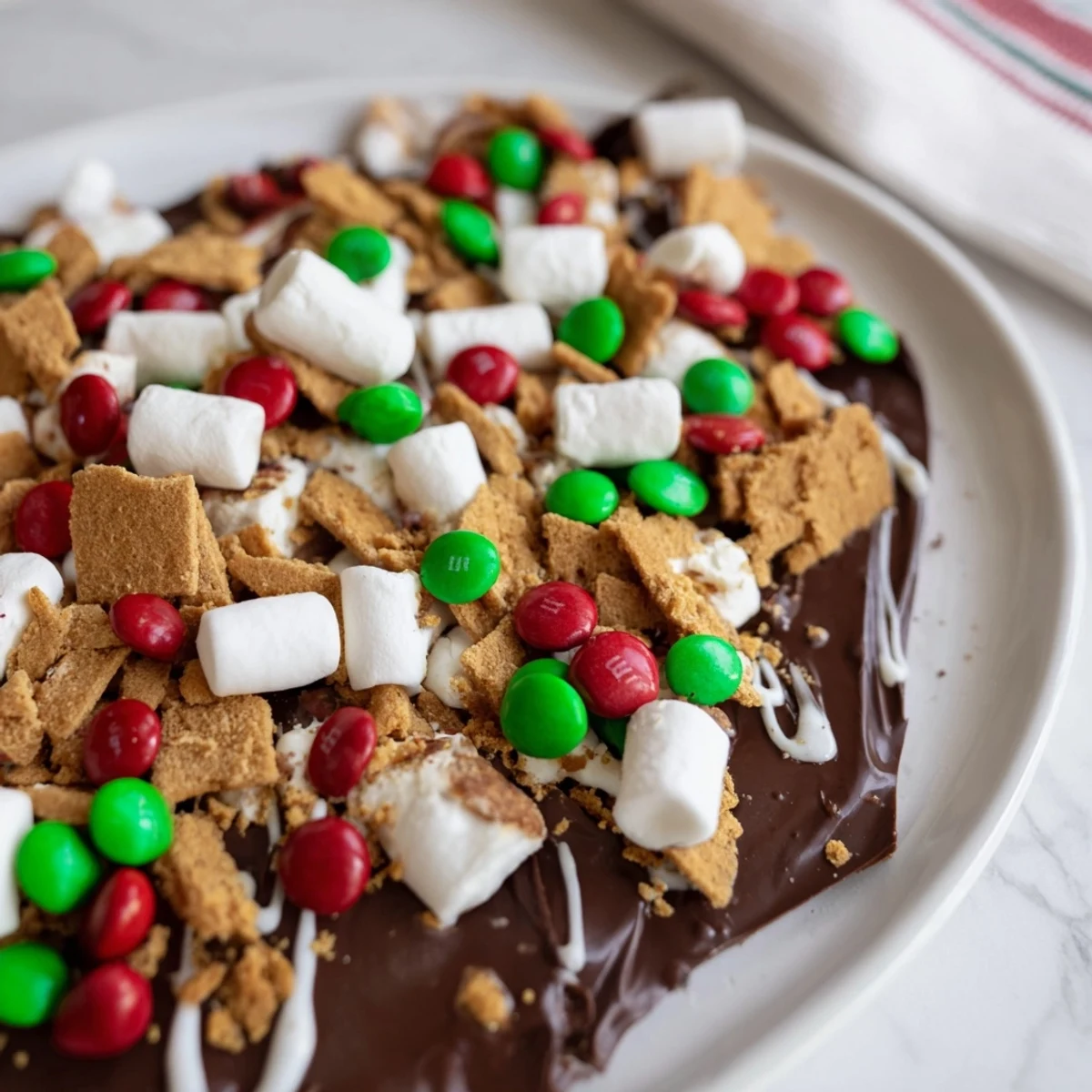 Quick Christmas Smores Bark: A close-up of festive, cracked bark with visible marshmallows and sprinkles.