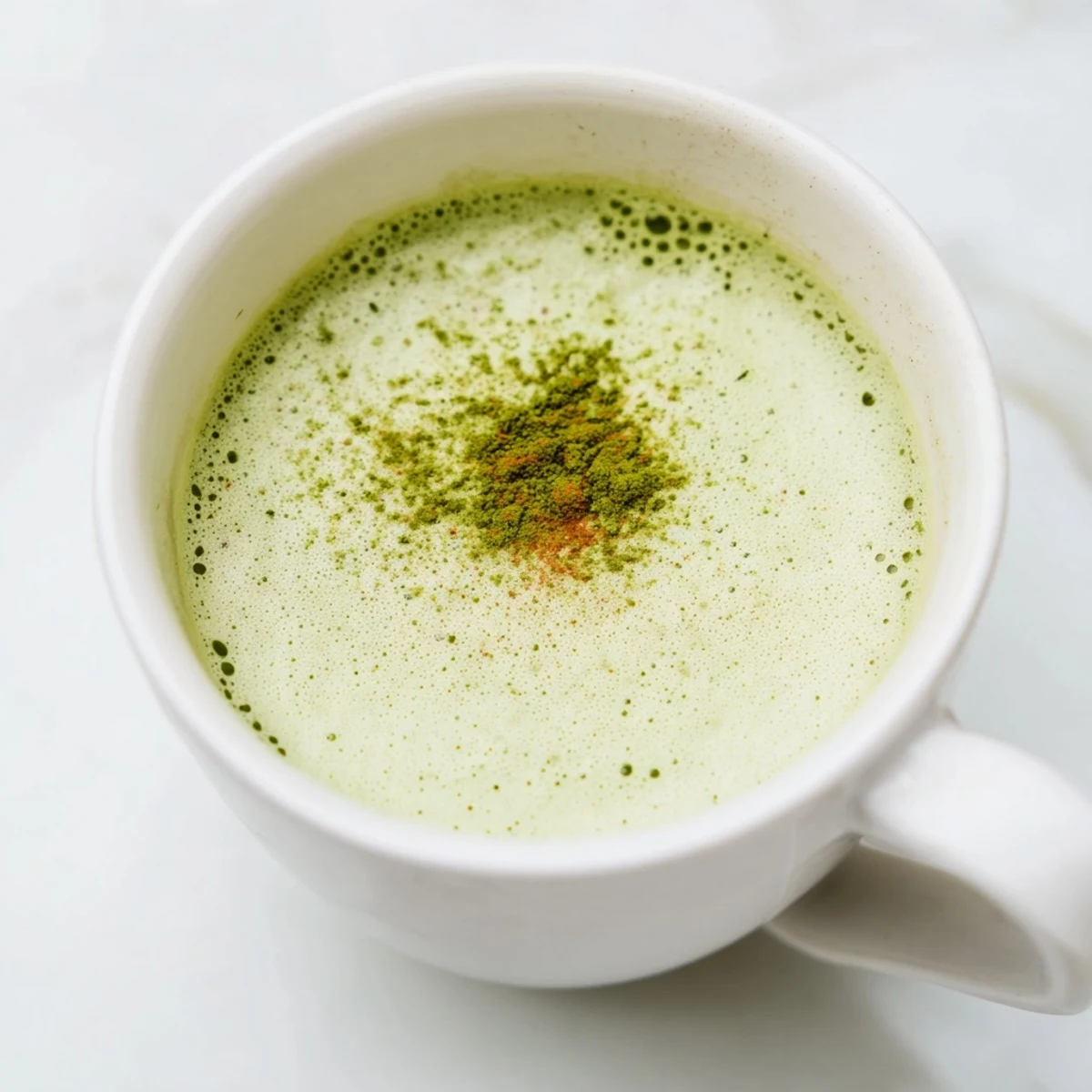 Steaming mug of Coconut Ginger Matcha Winter Immunity Latte, garnished and ready to sip on a cozy day.