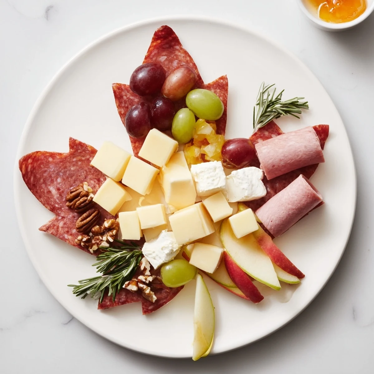 Imagine the charming maple leaf grazing tray: assorted cheeses, charcuterie, and colorful fruits ready to enjoy.