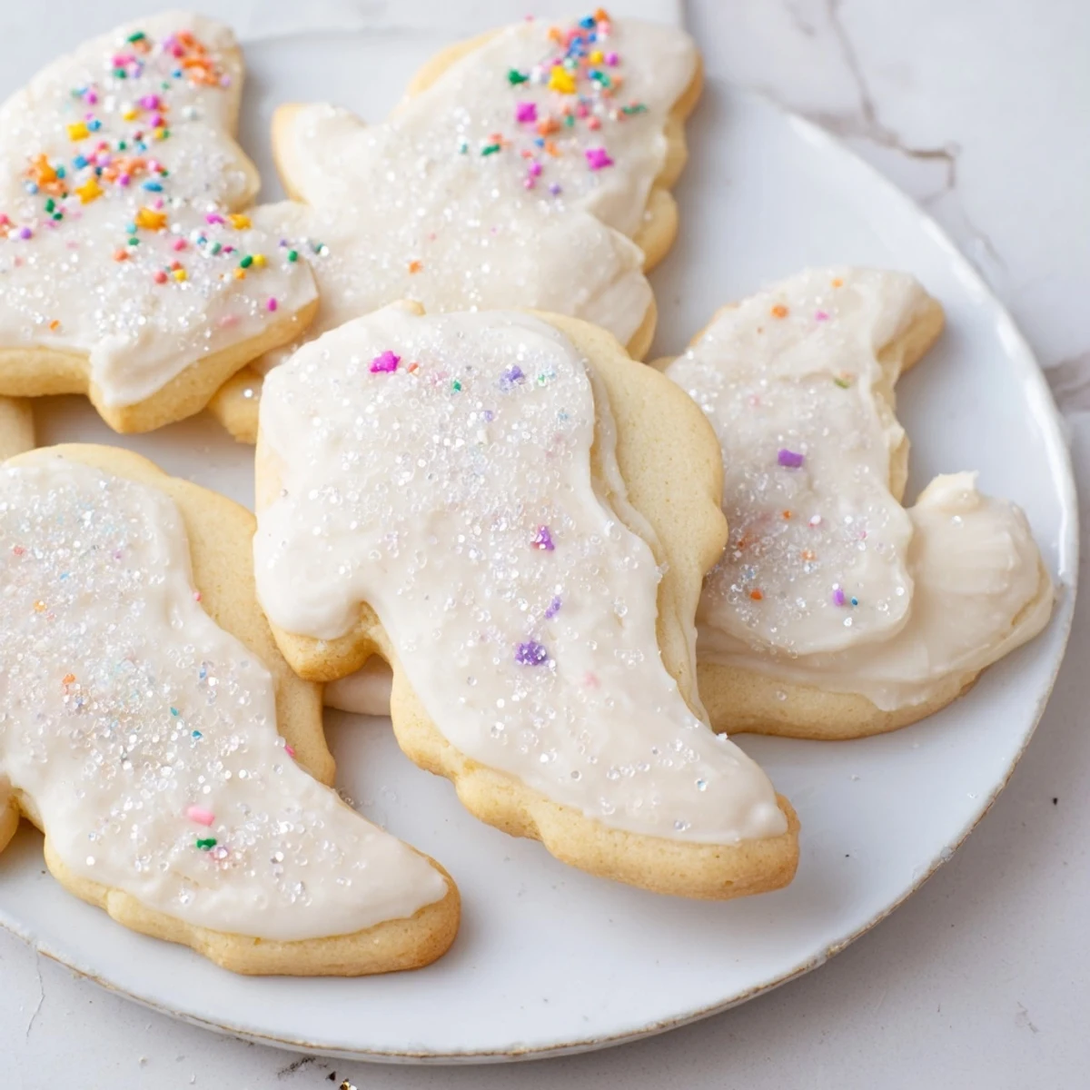 Close-up of freshly baked Angel Wings Sugar Cookies, beautifully decorated and sprinkled with edible glitter.