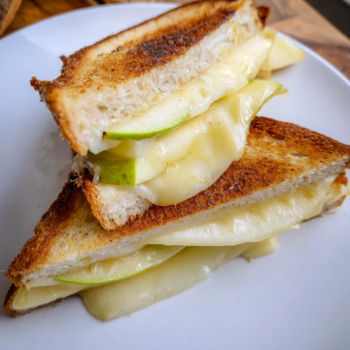 Perfectly browned Brie and Apple Grilled Cheese sandwich with crisp apple slices melting inside.