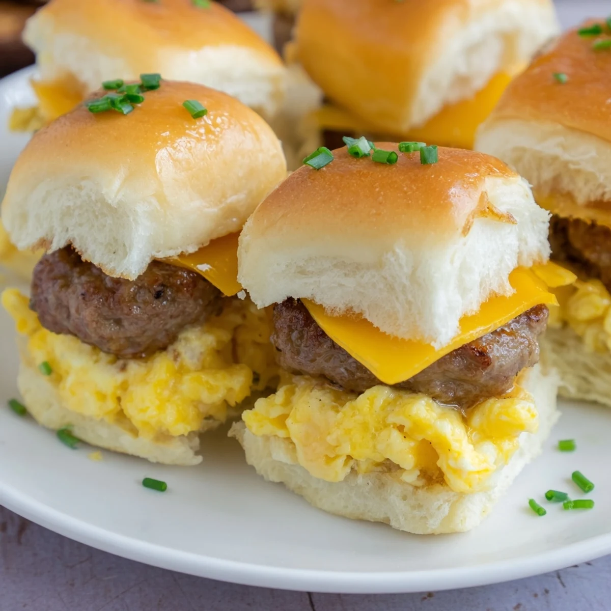 Fluffy eggs and melted cheese overflowing the soft buns of these mini breakfast sliders.