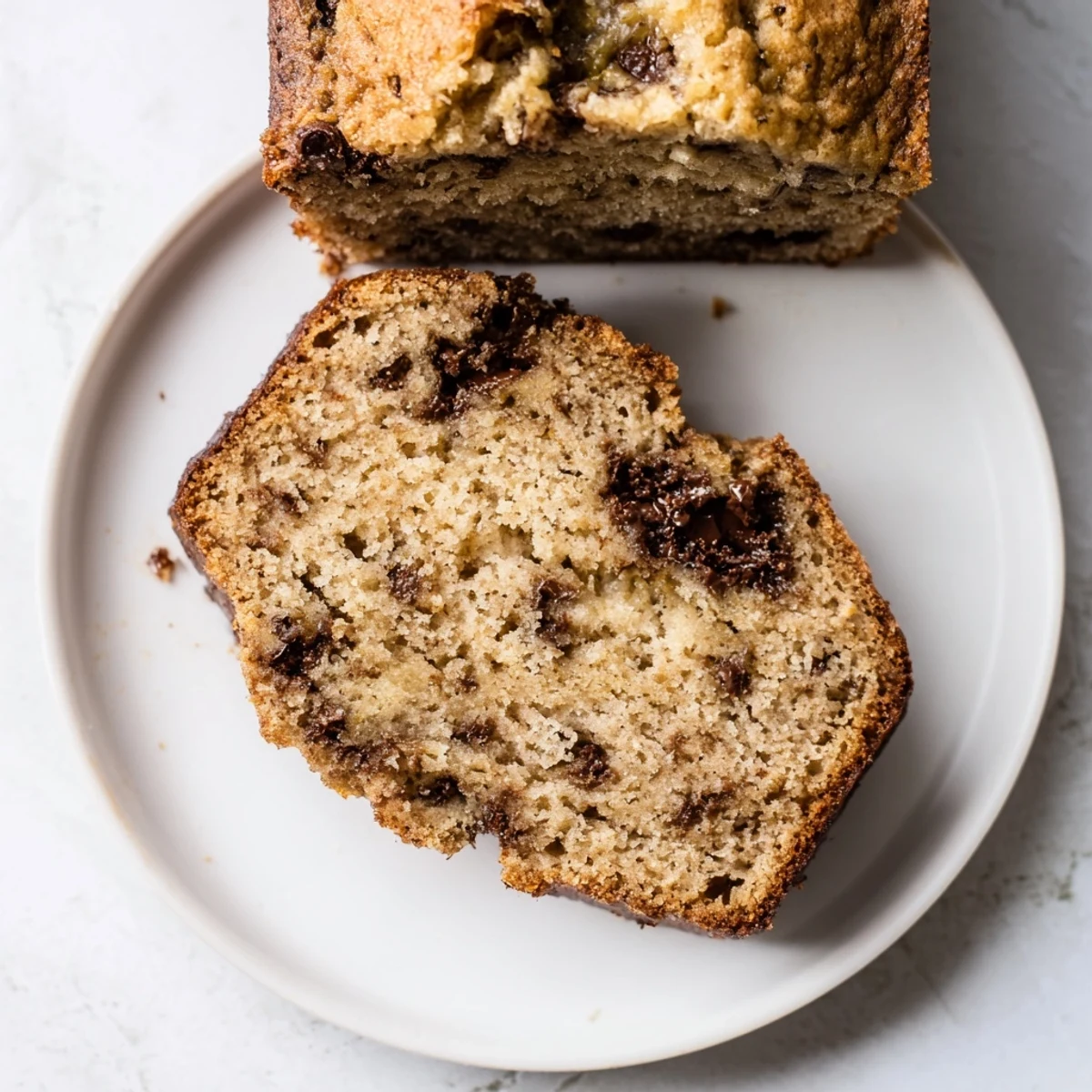 Golden-brown, moist banana bread variations in a loaf pan, topped with a sprinkle of sugar and ready to be sliced.