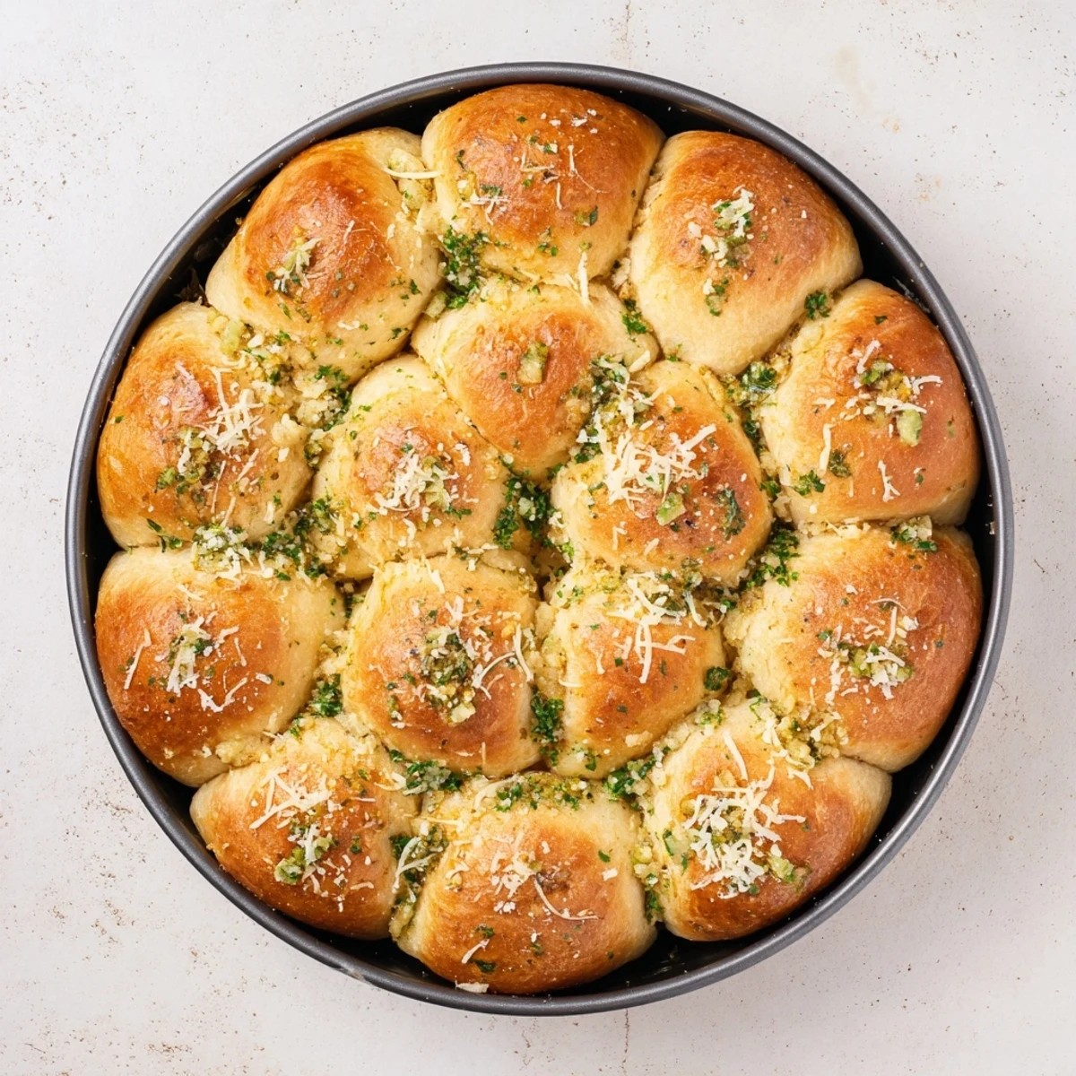 Garlic Butter Bread Pull-Apart rolls arranged in a skillet, with aromatic minced garlic and melted butter glistening on the golden-brown tops.