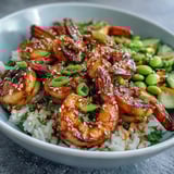 Vibrant Asian Shrimp Bowl with edamame, carrots, and cucumbers, finished with sesame seeds and scallions.