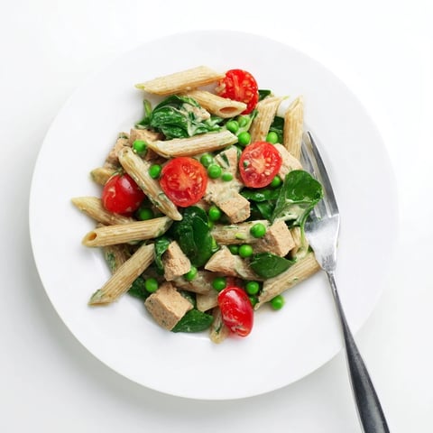 One-Pot Creamy Pesto Pea Protein Pasta: A steaming bowl of pasta, peas, and rich pesto, ready to eat.