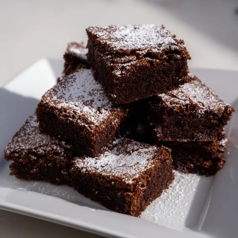 Fudgy brownie squares, dusted with powdered sugar, ready to eat, simple and delicious.