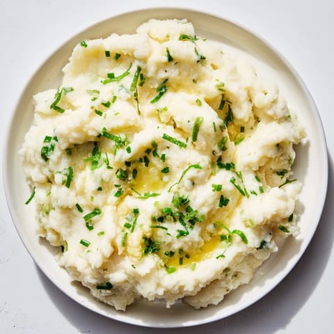 Steaming bowl of delicious cauliflower mash; garlicky, herby flavors perfect for a dinner.