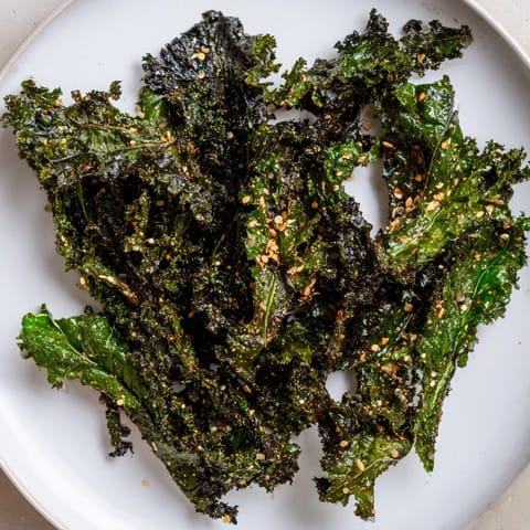 Savory and crunchy baked kale chips, described perfectly to satisfy any hunger craving, delicious.