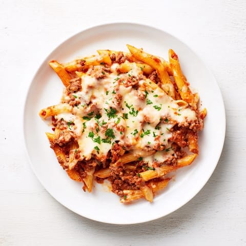 Golden, cheesy crust on a hearty Budget Sausage and Cheese Pasta Bake with savory sausage and sauce.