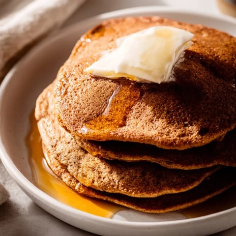A stack of fluffy Gingerbread Pancakes, smelling of warm spices, is perfect for a cozy brunch.