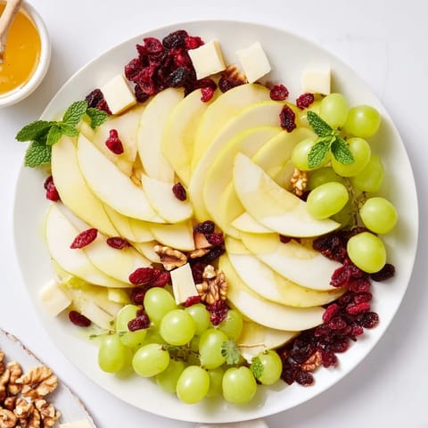 A beautifully arranged Apple Orchard Fruit Board offering a colorful array of fresh fruits and nuts.