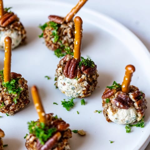 Festively arranged acorn cheese ball bites, starring a delicious cream cheese and cheddar mixture.
