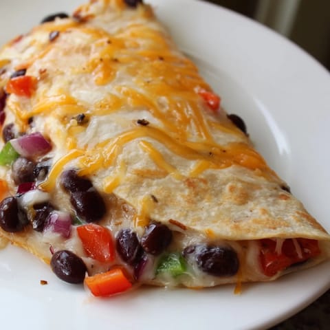 Close-up of a bubbling, cheesy Black Bean Quesadilla with vibrant peppers, perfect for a quick dinner.