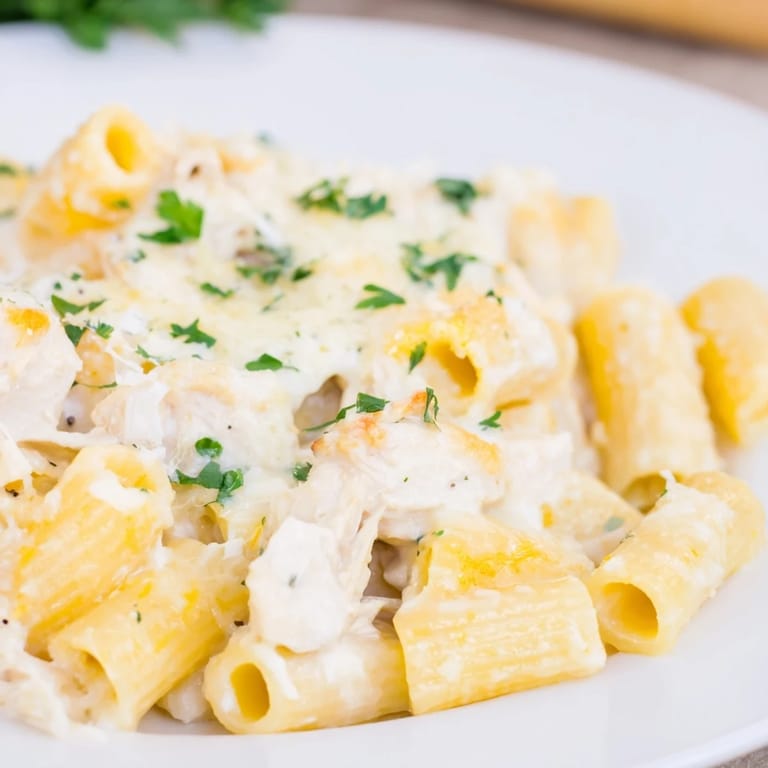 A close-up of a Chicken Alfredo Bake, showing tender chicken pieces in a rich, cheesy pasta.