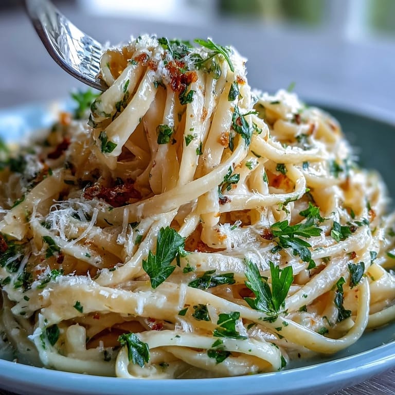Elegant lemon butter pasta with peas, topped with Parmesan and parsley, served on a rustic wooden table.